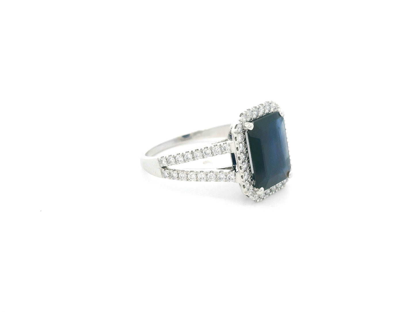 Emerald cut blue sapphire halo ring in 18K white gold with diamond split band Emirates Diamonds