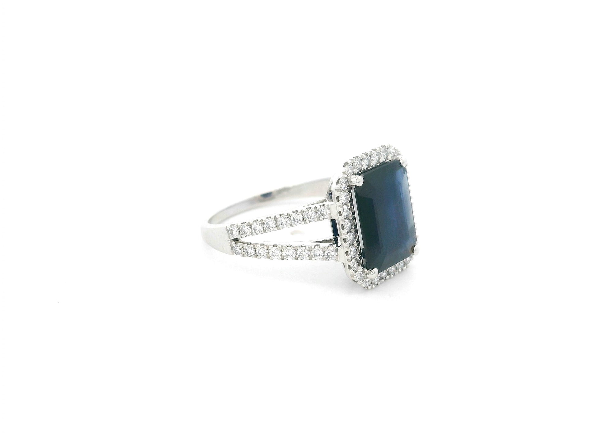 Emerald cut blue sapphire halo ring in 18K white gold with diamond split band Emirates Diamonds