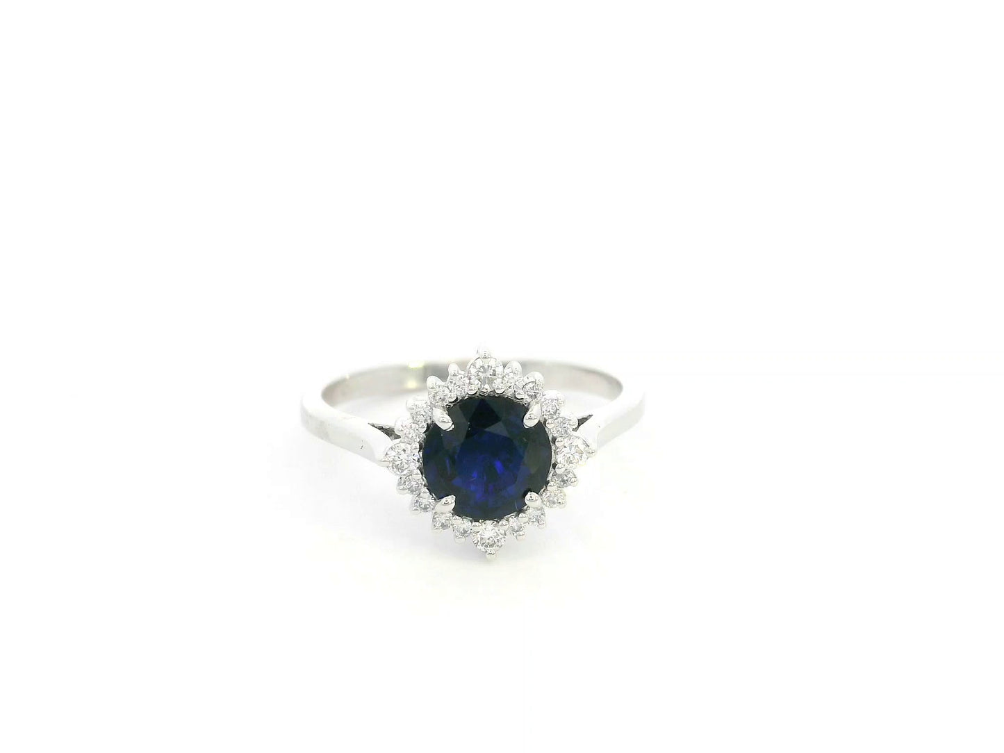 Blue sapphire and diamond halo ring in 18K white gold featuring a 1.24 carat natural blue sapphire and 0.18 carat diamonds