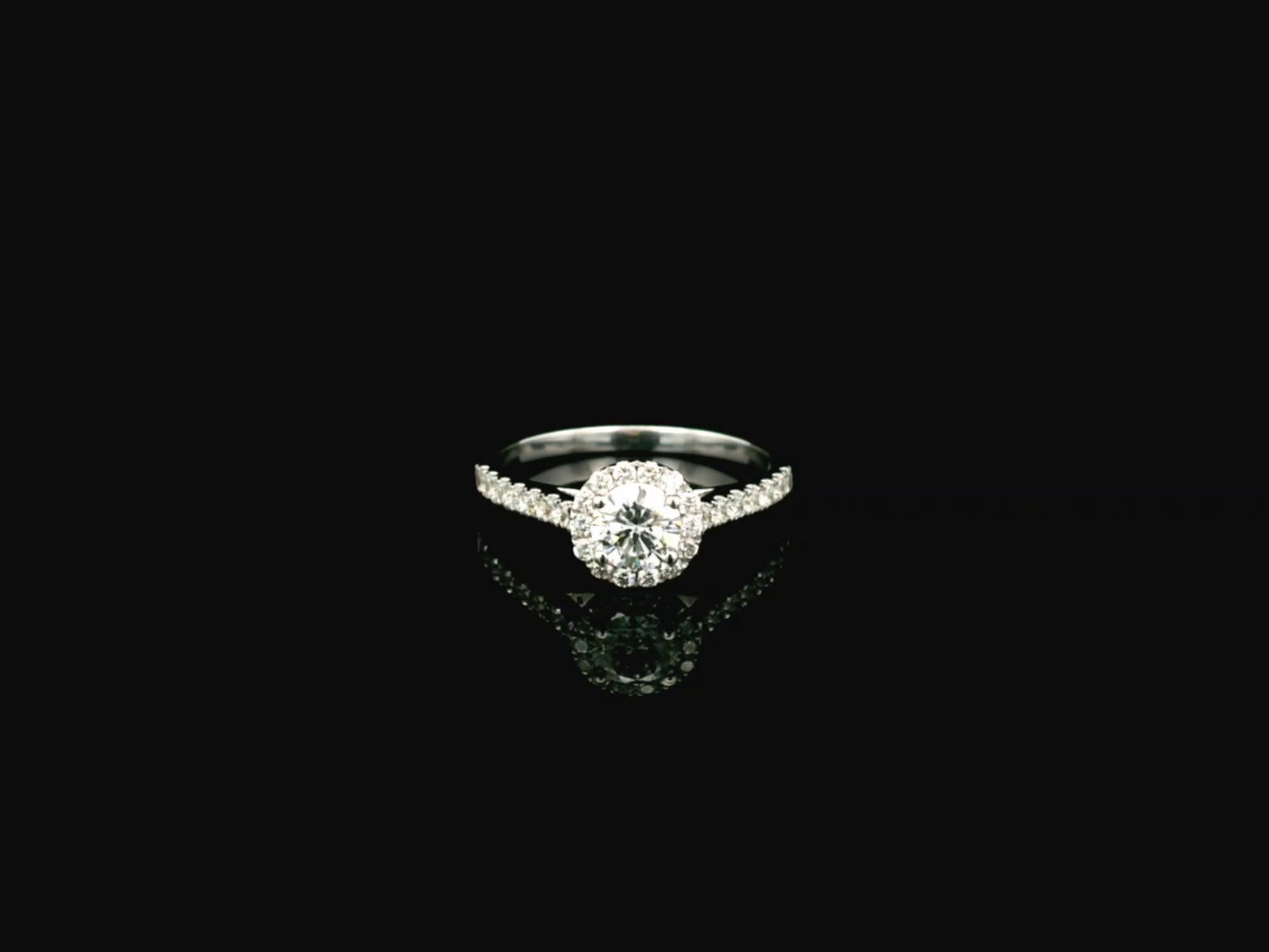 GIA certified round diamond halo engagement ring in 18K white gold with pavé diamond band