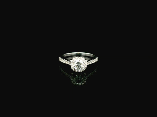 GIA certified round diamond halo engagement ring in 18K white gold with pavé diamond band