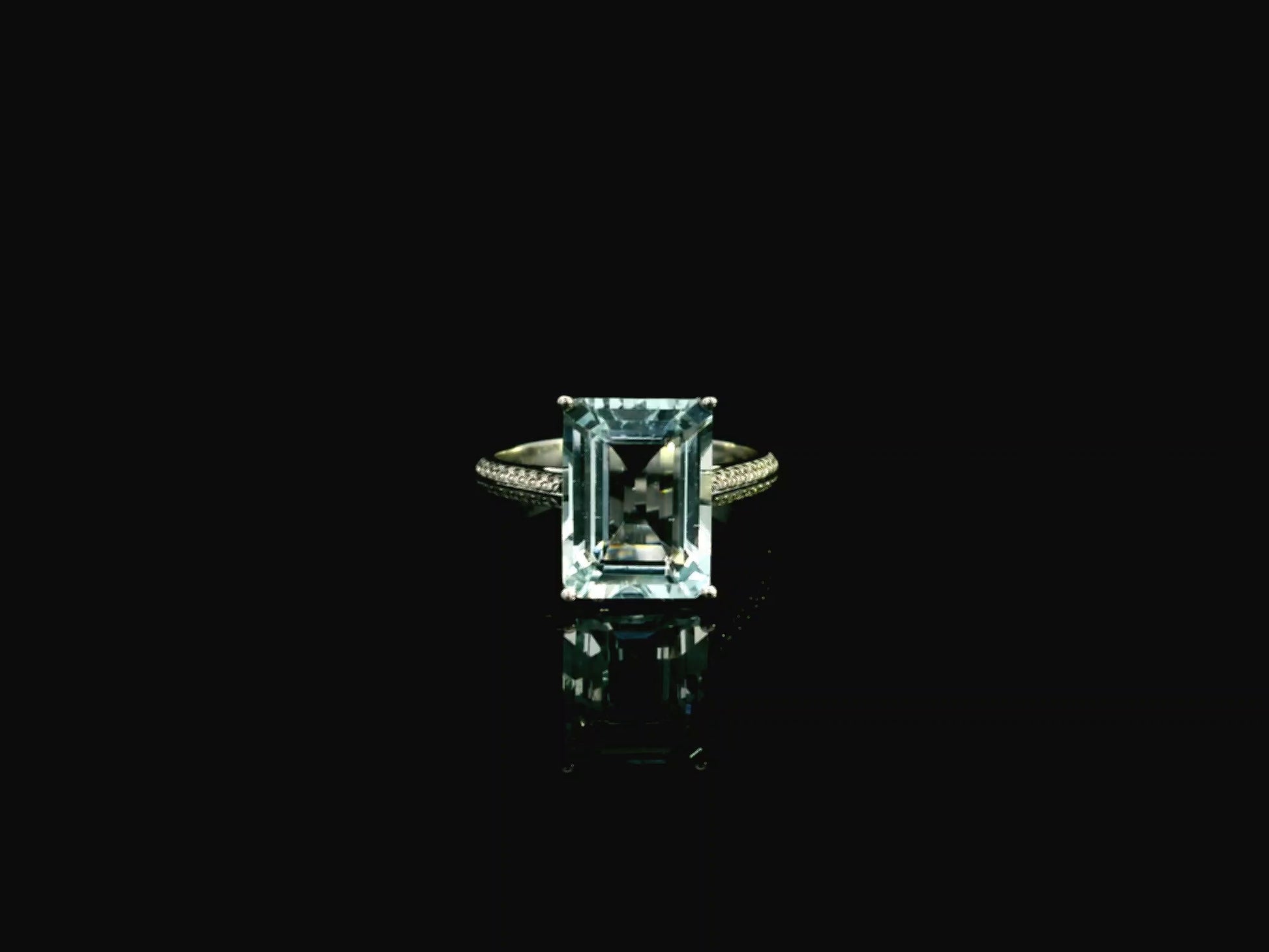 Emerald cut aquamarine ring in 18K white gold with pavé diamond band
