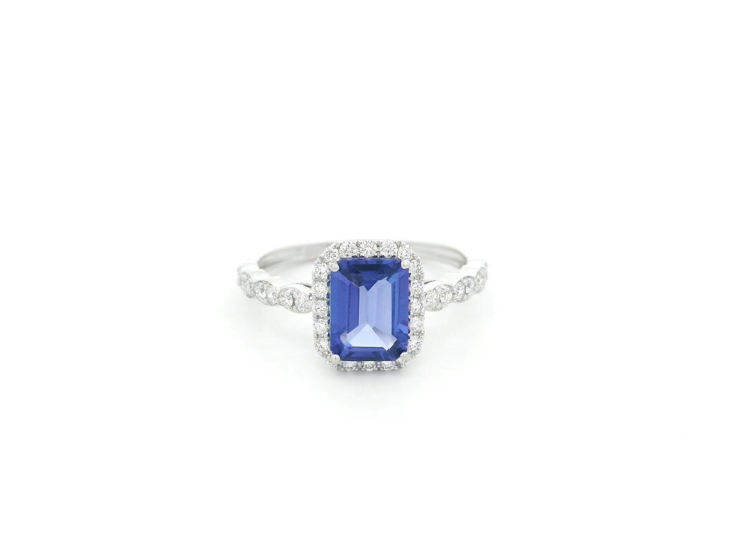 Emerald cut tanzanite halo ring in 18K white gold with marquise diamond band
