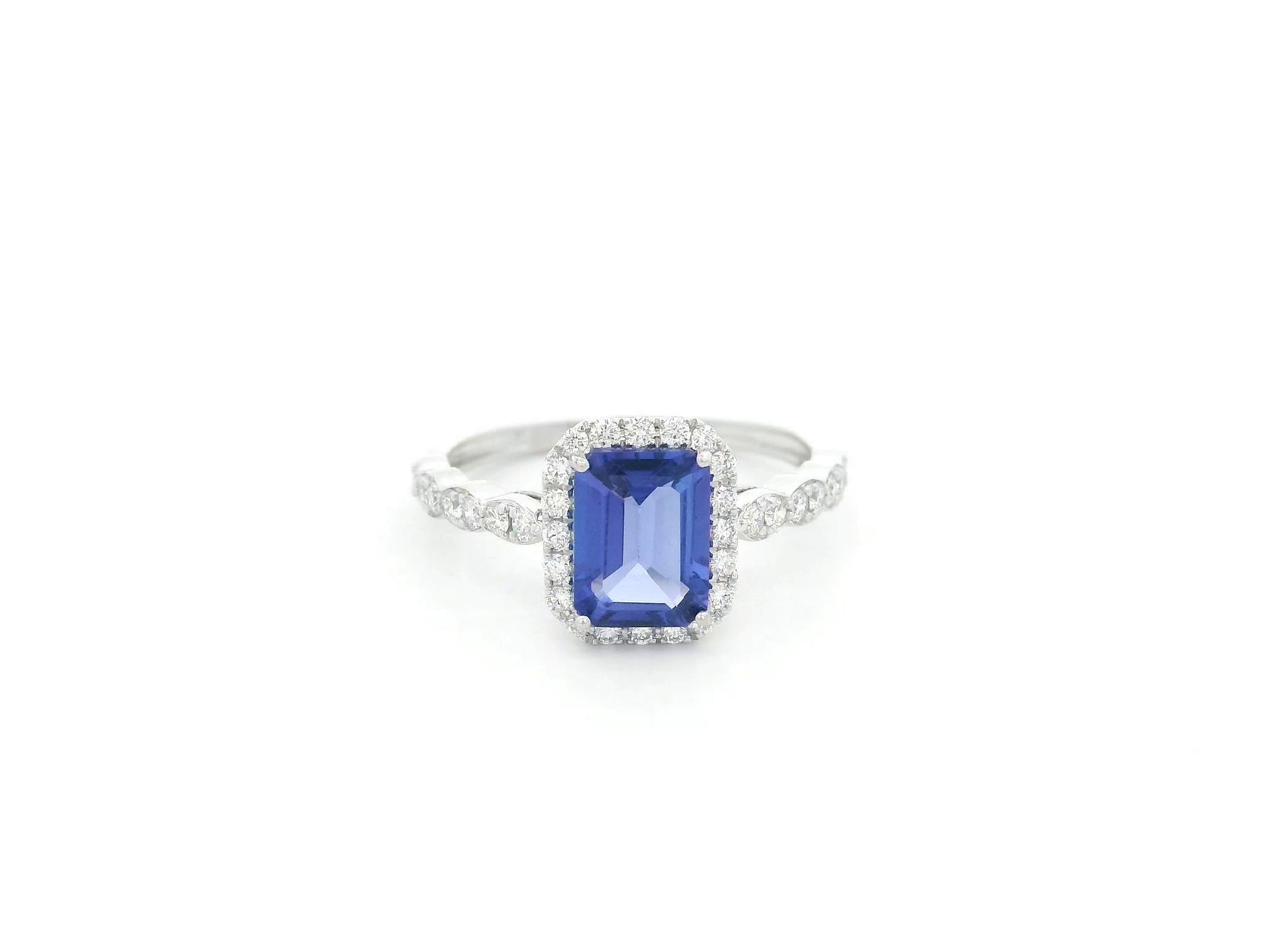 Emerald cut tanzanite halo ring in 18K white gold with marquise diamond band
