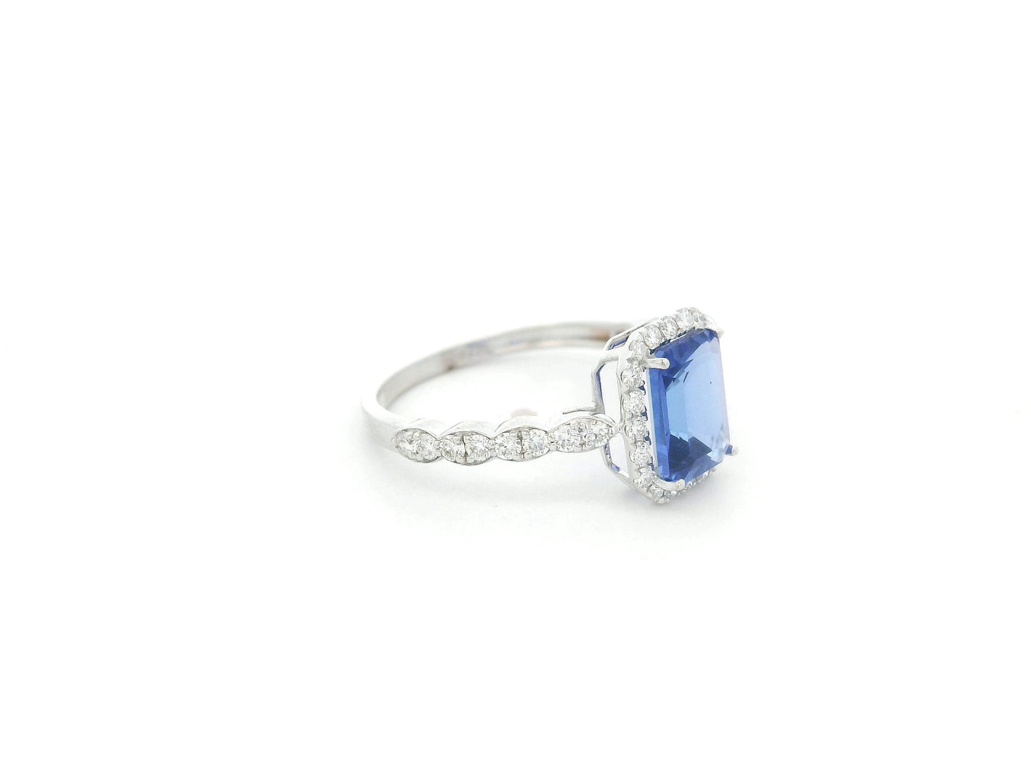 Emerald cut tanzanite halo ring in 18K white gold with marquise diamond band