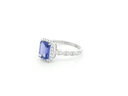 Emerald cut tanzanite halo ring in 18K white gold with marquise diamond band