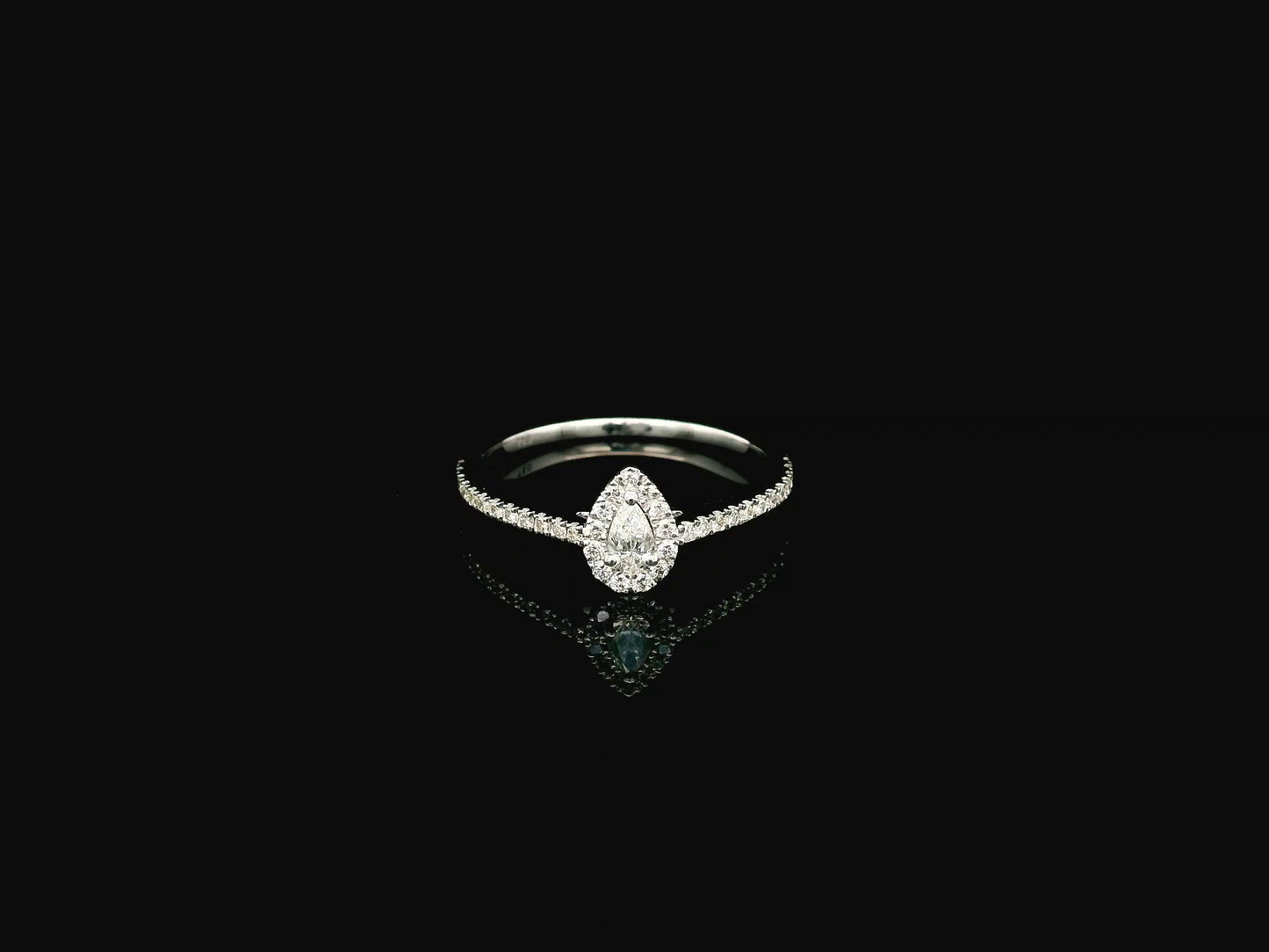 Natural pear shape diamond halo ring in solid 18K white gold featuring a pear-shaped centre diamond with a round brilliant diamond halo and pavé diamond band.