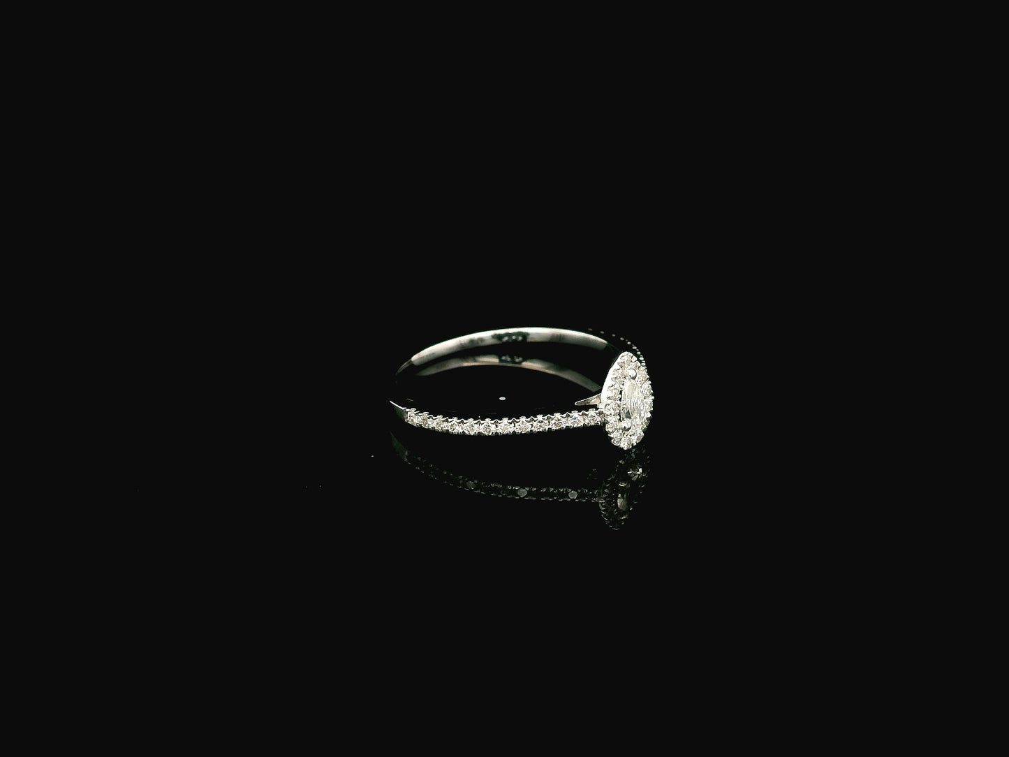 Natural pear shape diamond halo ring in solid 18K white gold featuring a pear-shaped centre diamond with a round brilliant diamond halo and pavé diamond band.