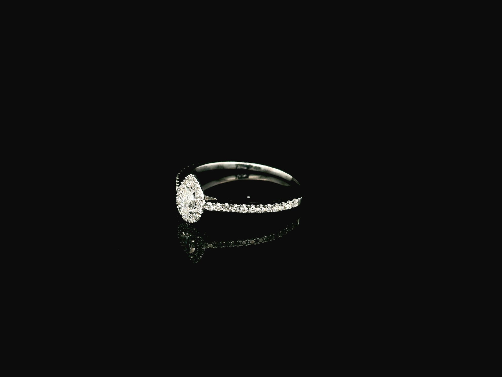 Natural pear shape diamond halo ring in solid 18K white gold featuring a pear-shaped centre diamond with a round brilliant diamond halo and pavé diamond band.