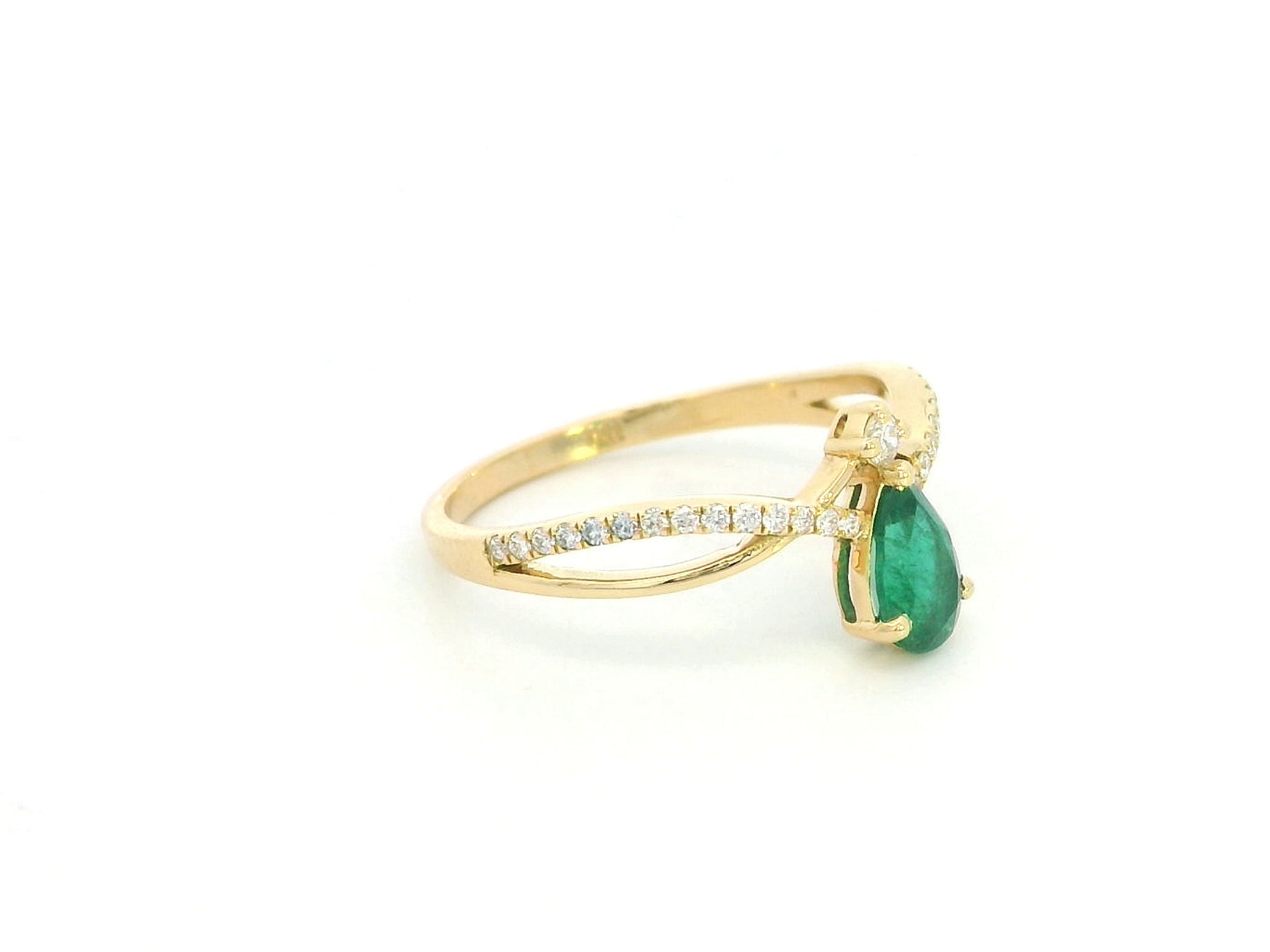 Pear shaped emerald and diamond crossover ring in 18K yellow gold