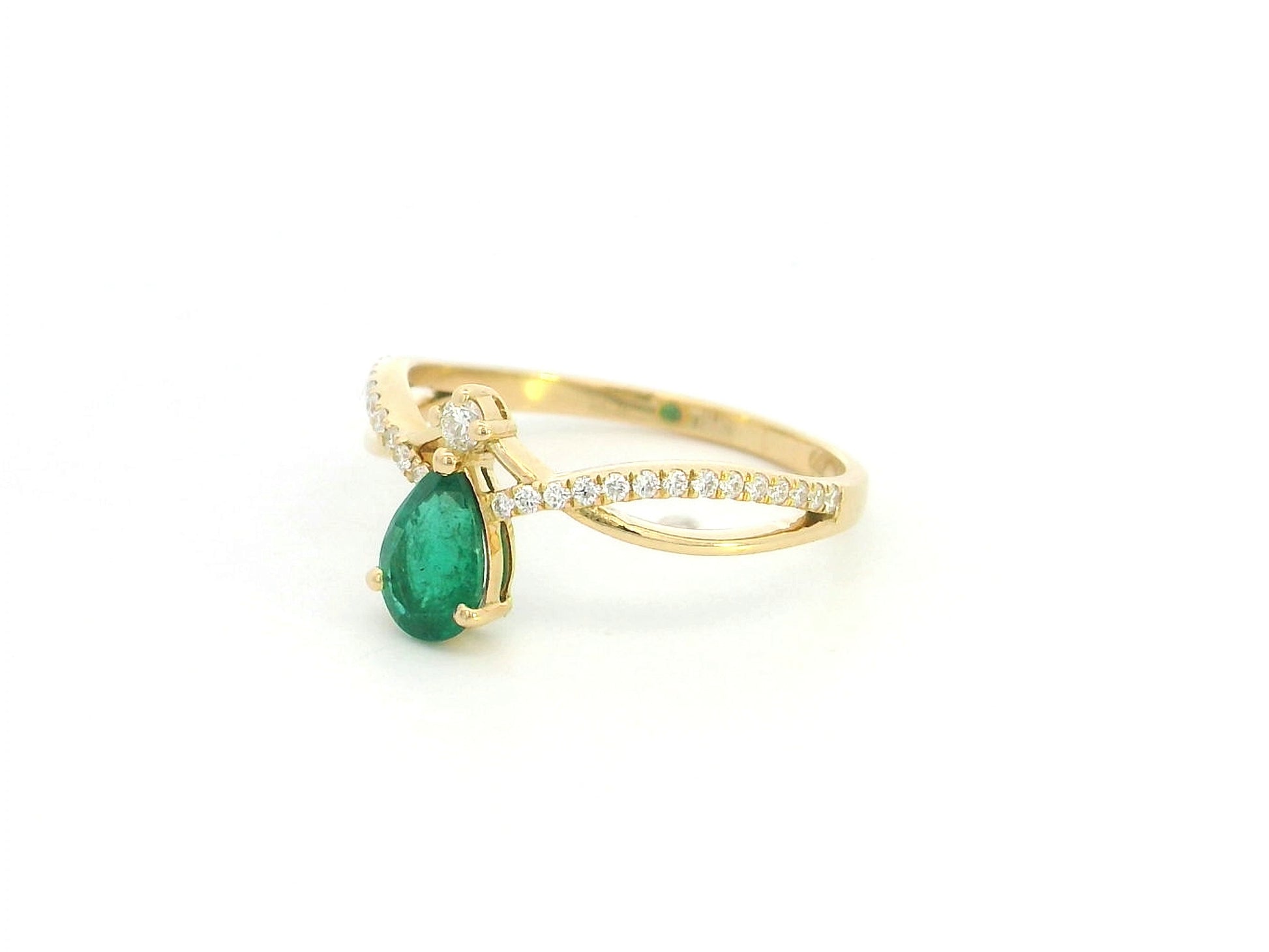 Pear shaped emerald and diamond crossover ring in 18K yellow gold