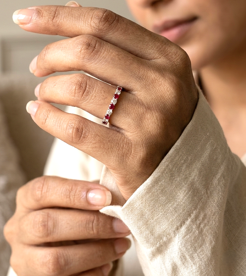 Ruby and diamond half eternity ring in 18K white gold with alternating round rubies and diamonds.