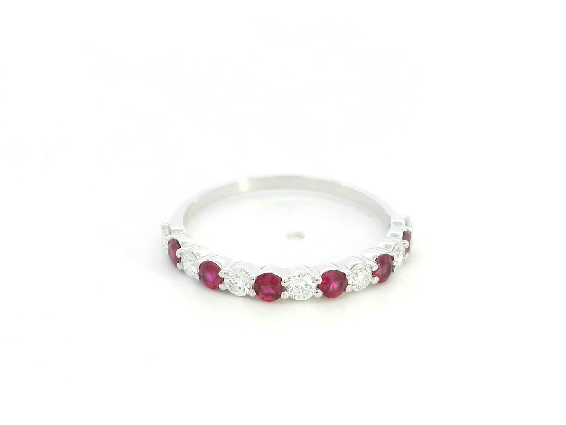 Ruby and diamond half eternity ring in 18K white gold with alternating round rubies and diamonds.