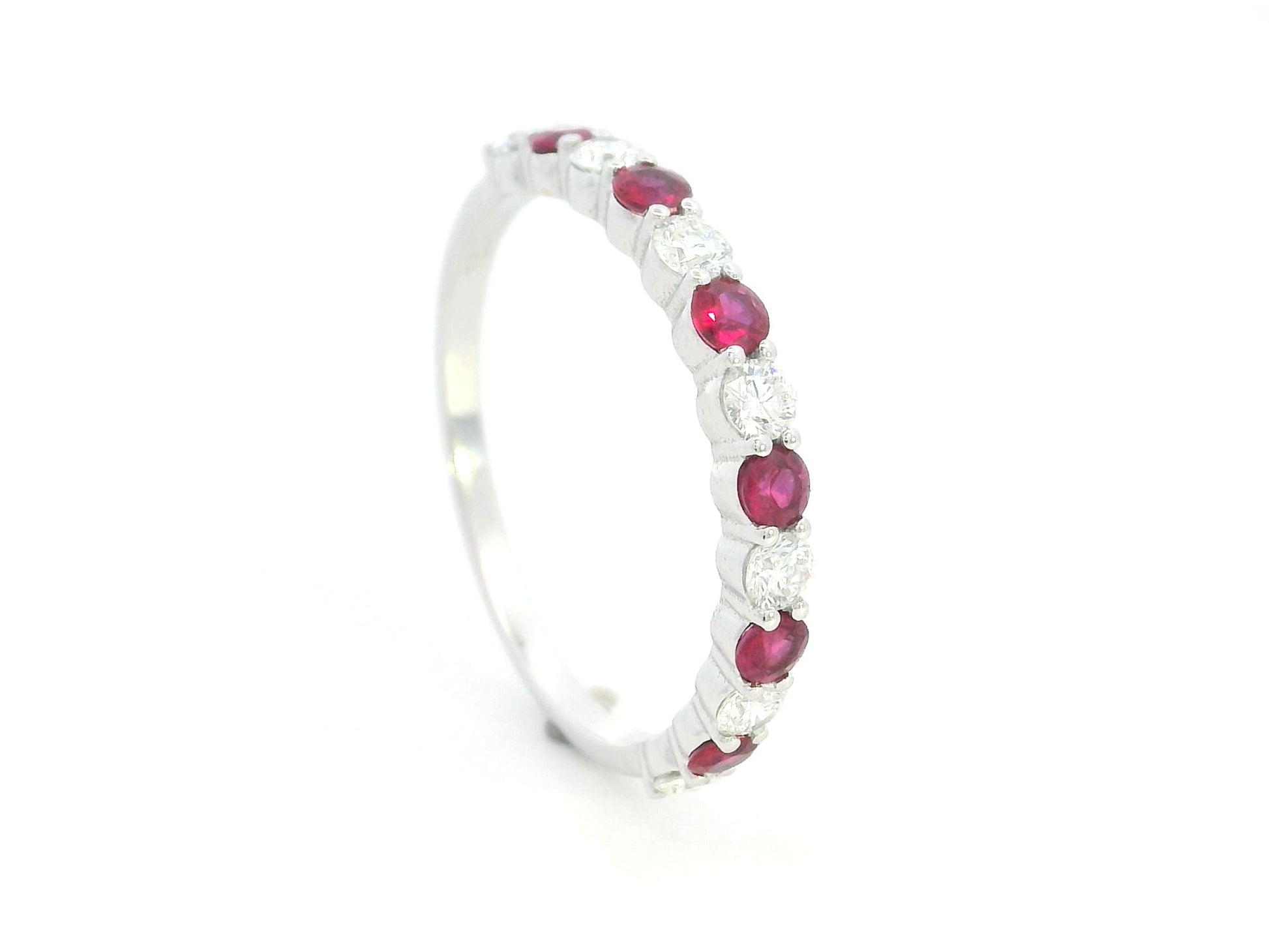 Ruby and diamond half eternity ring in 18K white gold with alternating round rubies and diamonds.