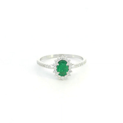 Natural oval emerald ring in 18K white gold featuring a 0.35 carat emerald surrounded by a diamond halo with 0.23 carat total diamond weight.