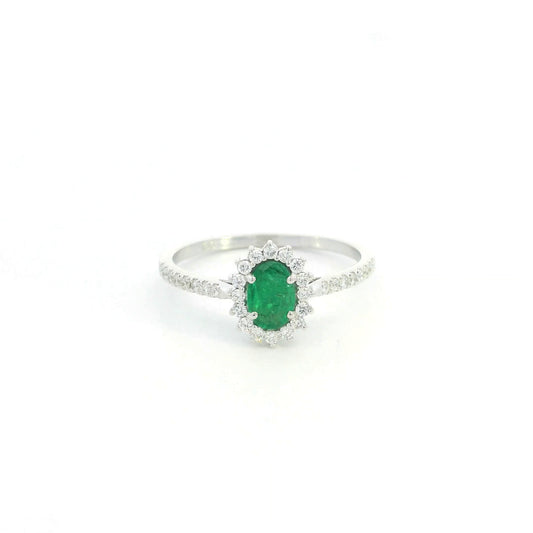 Natural oval emerald ring in 18K white gold featuring a 0.35 carat emerald surrounded by a diamond halo with 0.23 carat total diamond weight.