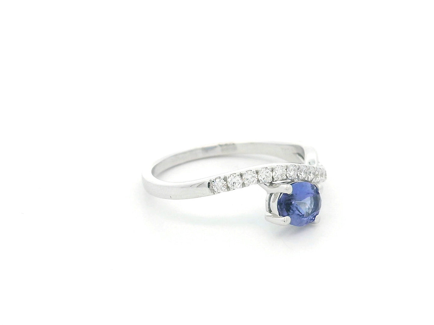 18K white gold tanzanite ring featuring a 0.70 carat oval-cut tanzanite and 0.23 carats of natural diamonds in a crossover design.