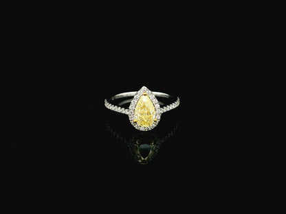 Fancy yellow pear-shaped diamond halo ring in 18K white gold with pavé diamond band and GIA certified center stone.