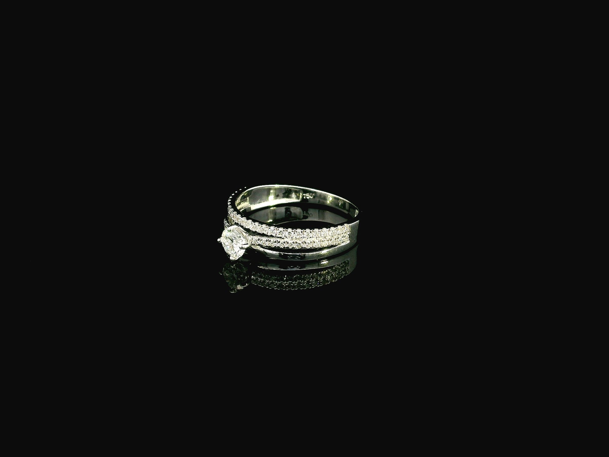 18K white gold diamond engagement ring featuring a 0.30 carat round center diamond and triple-row band with 0.28 carats of accent diamonds.