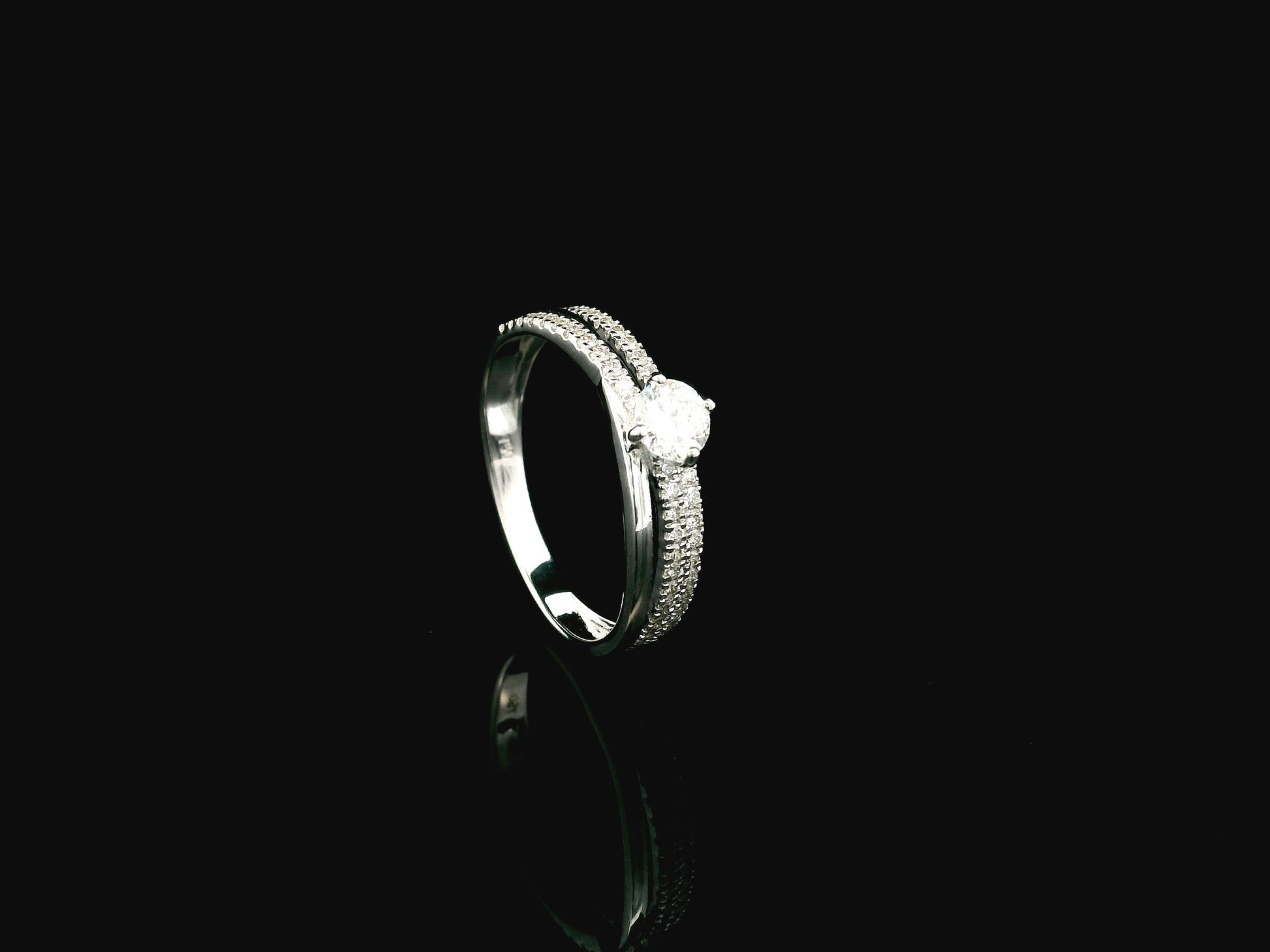 18K white gold diamond engagement ring featuring a 0.30 carat round center diamond and triple-row band with 0.28 carats of accent diamonds.