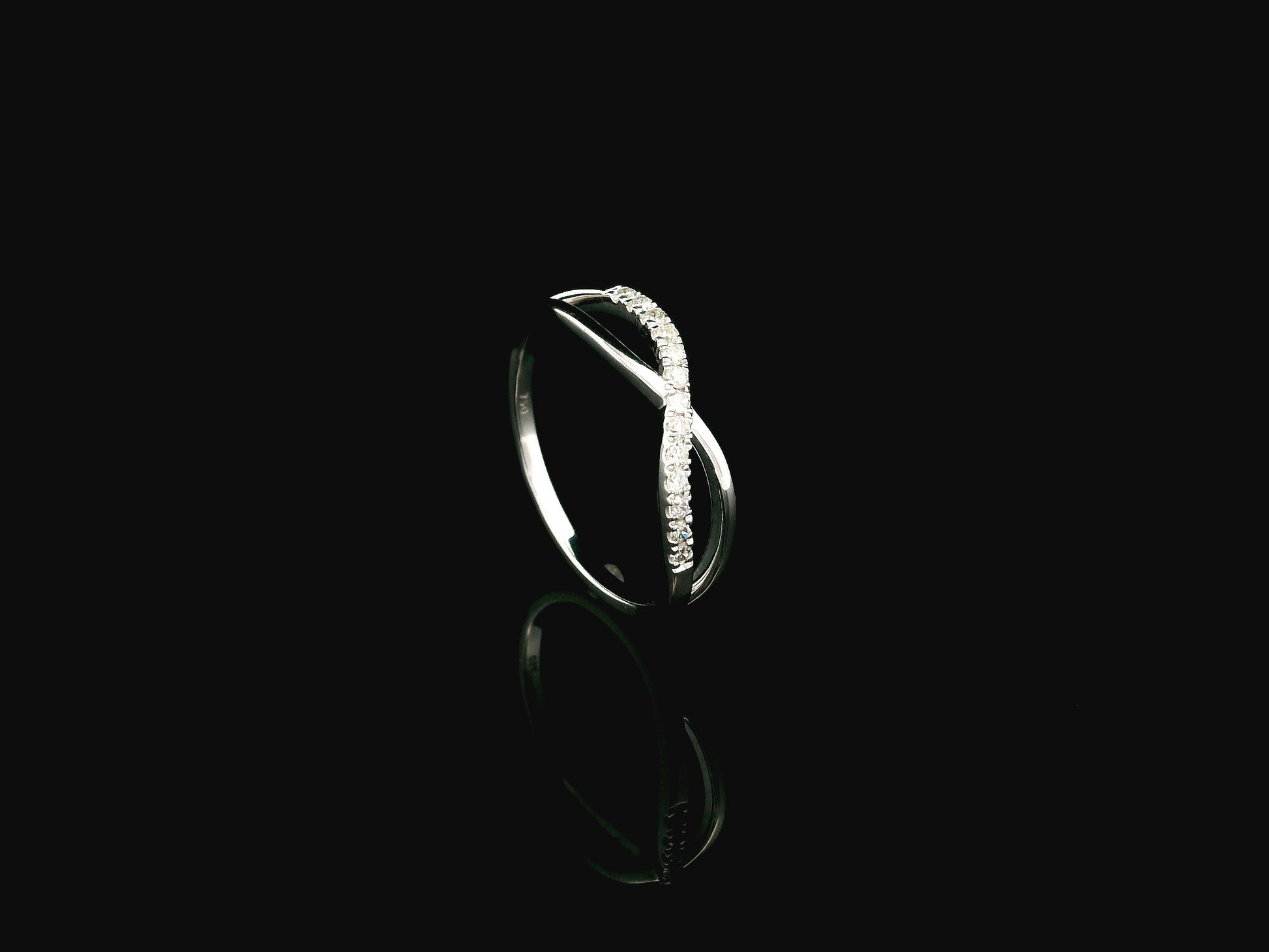 18K white gold diamond crossover ring featuring a crisscross design with 0.16 carat natural diamonds and polished white gold bands.