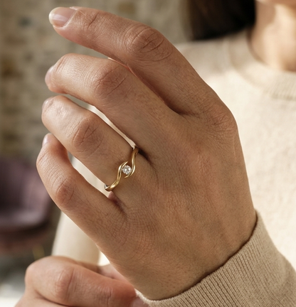Solitaire diamond twist ring in 18K yellow gold featuring a 0.10 carat natural diamond