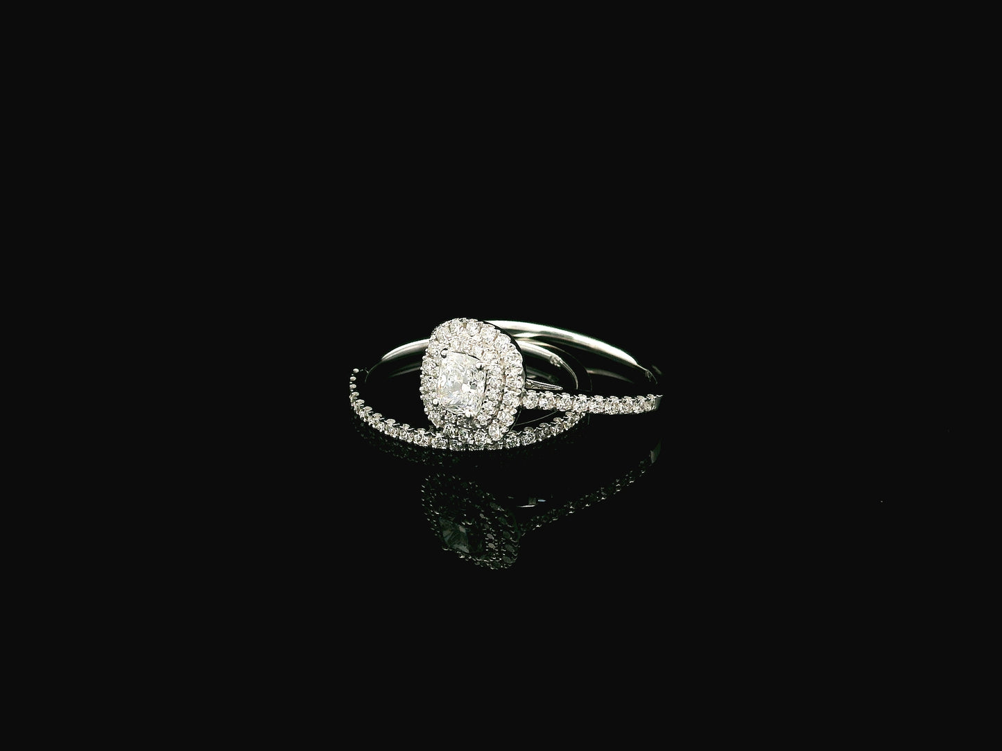 GIA certified cushion cut diamond bridal ring set in 18K white gold with halo engagement ring and matching diamond wedding band.