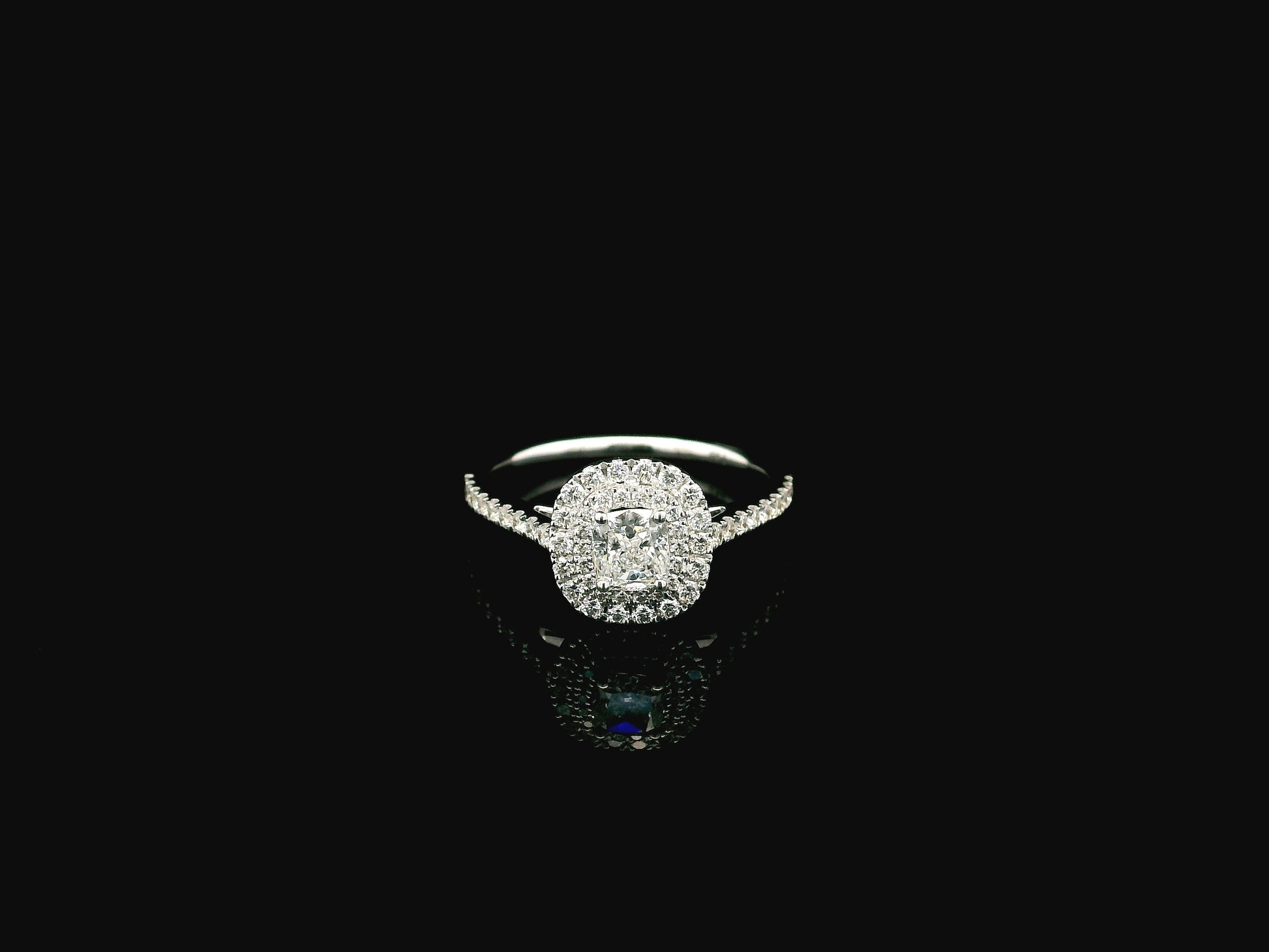 GIA certified cushion cut diamond bridal ring set in 18K white gold with halo engagement ring and matching diamond wedding band.