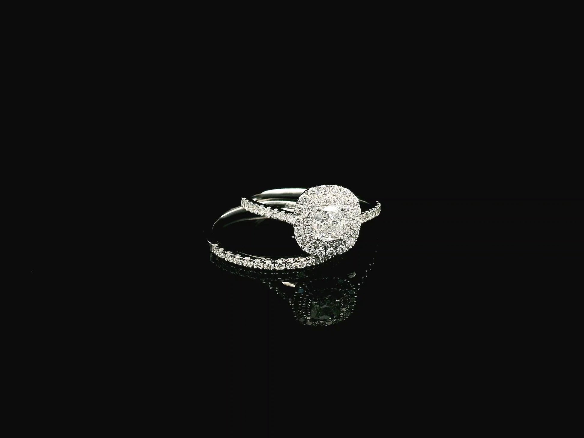 GIA certified cushion cut diamond bridal ring set in 18K white gold with halo engagement ring and matching diamond wedding band.