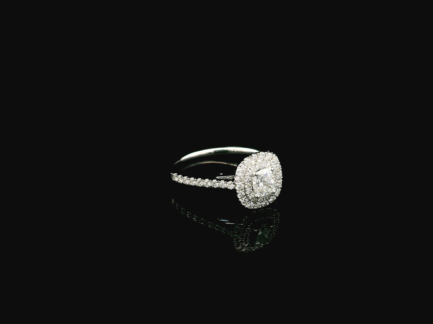 GIA certified cushion cut diamond bridal ring set in 18K white gold with halo engagement ring and matching diamond wedding band.