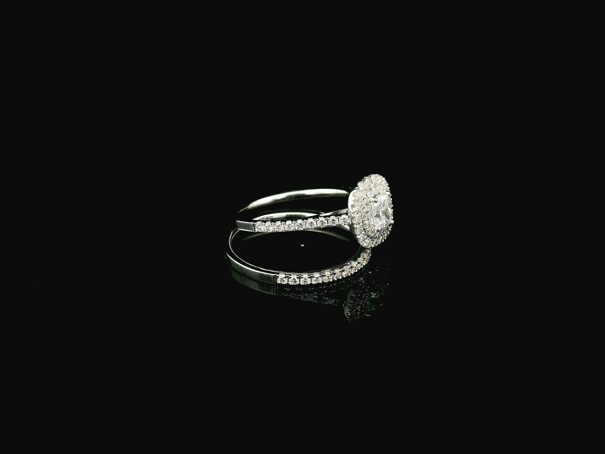 GIA certified cushion cut diamond bridal ring set in 18K white gold with halo engagement ring and matching diamond wedding band.