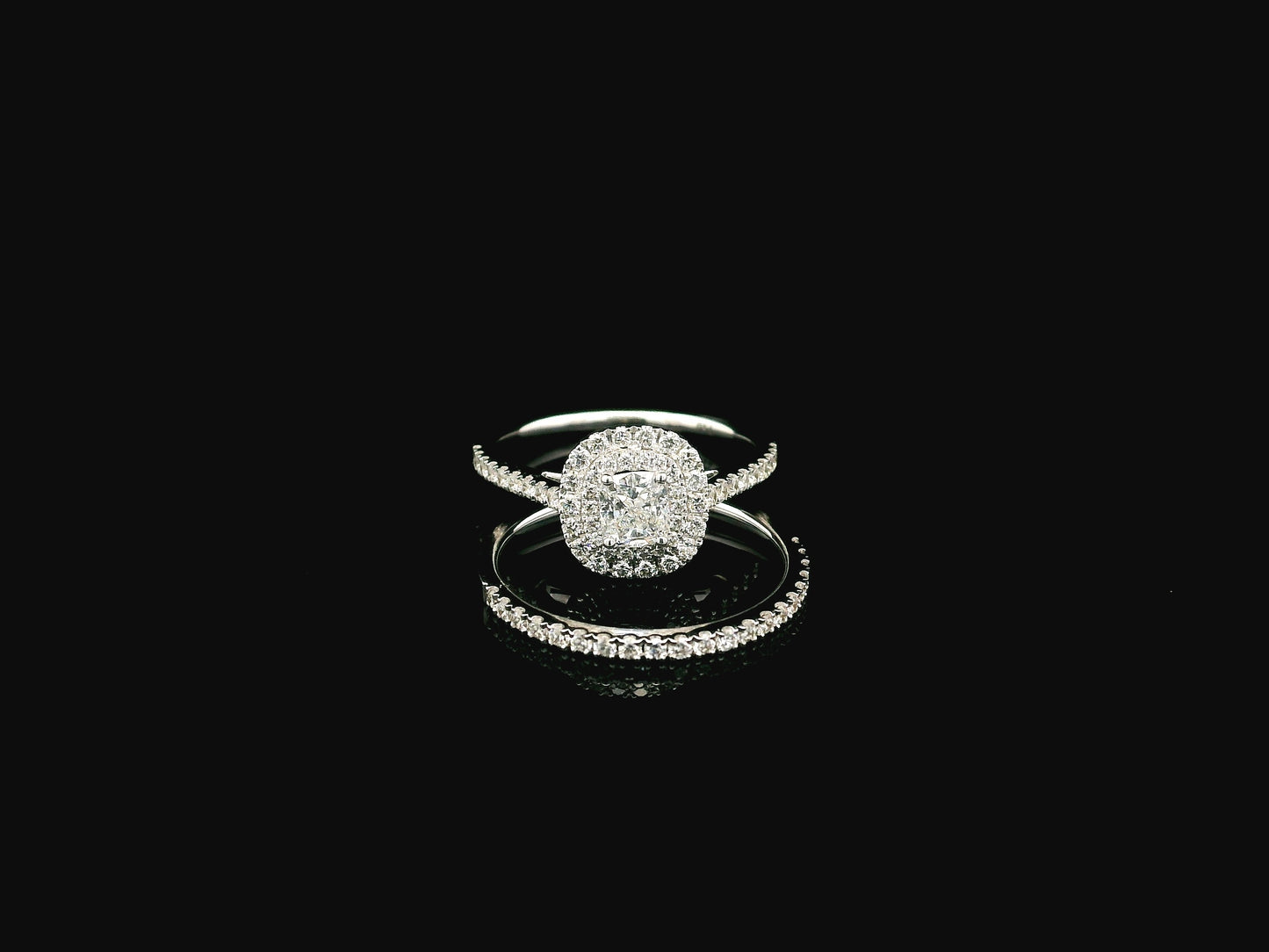 GIA certified cushion cut diamond bridal ring set in 18K white gold with halo engagement ring and matching diamond wedding band.