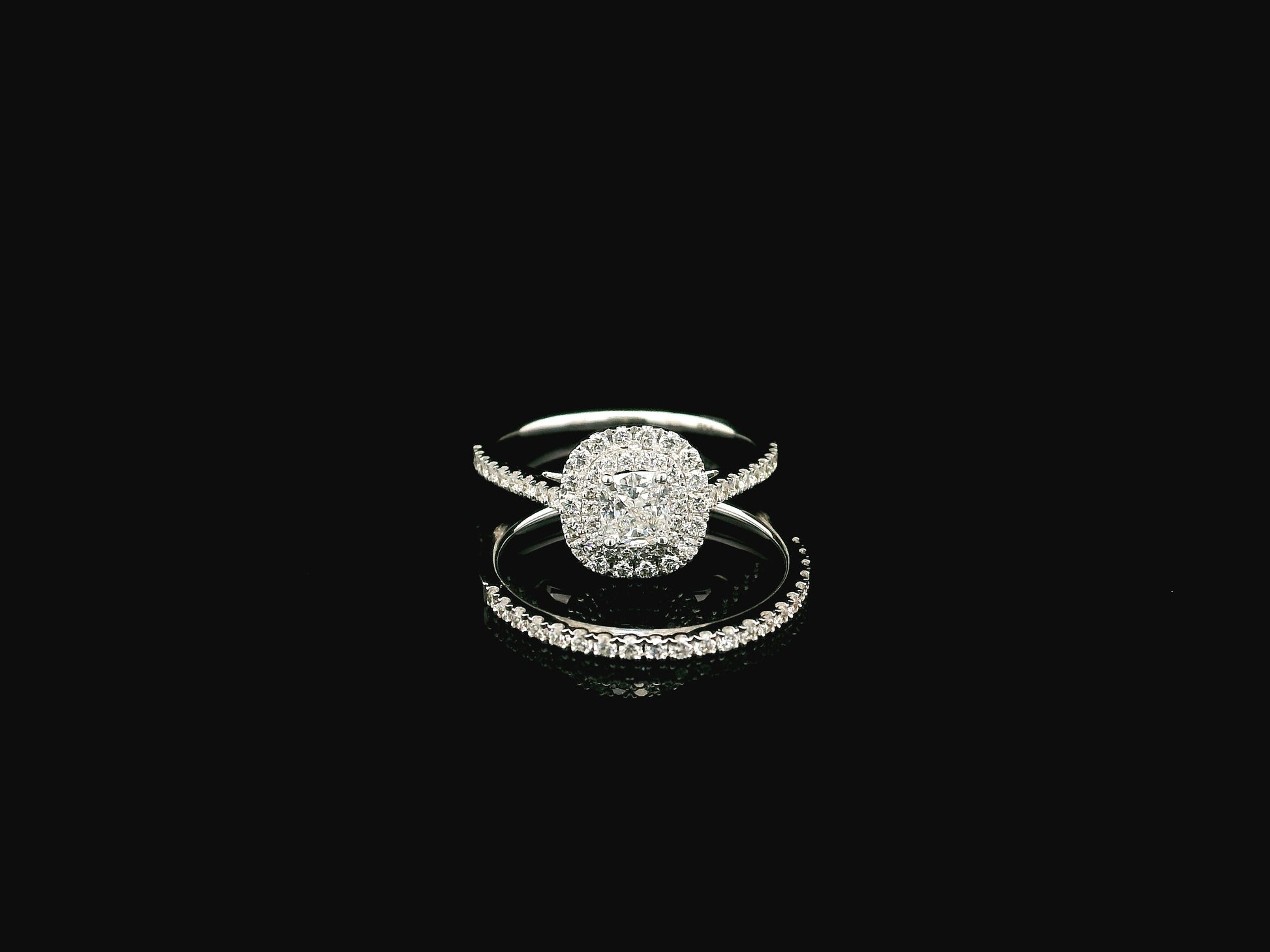 GIA certified cushion cut diamond bridal ring set in 18K white gold with halo engagement ring and matching diamond wedding band.
