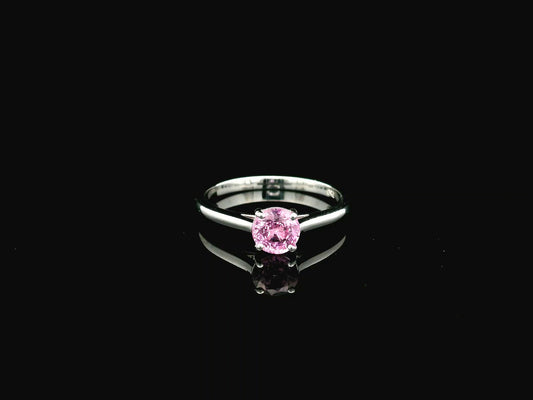 18K white gold pink sapphire solitaire ring featuring a 0.91 carat round pink sapphire in a classic four-prong setting
