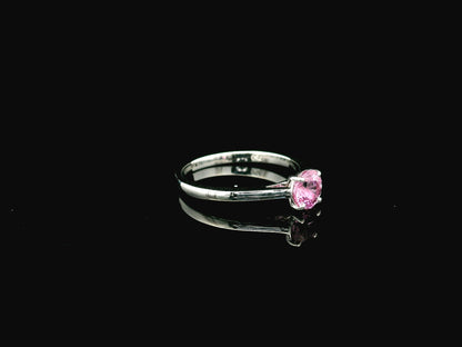 18K white gold pink sapphire solitaire ring featuring a 0.91 carat round pink sapphire in a classic four-prong setting