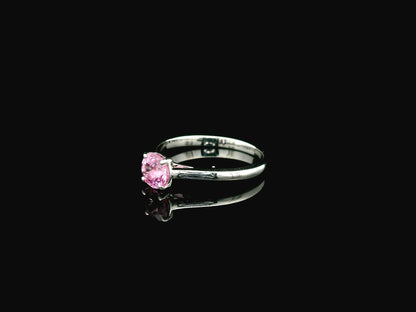 18K white gold pink sapphire solitaire ring featuring a 0.91 carat round pink sapphire in a classic four-prong setting