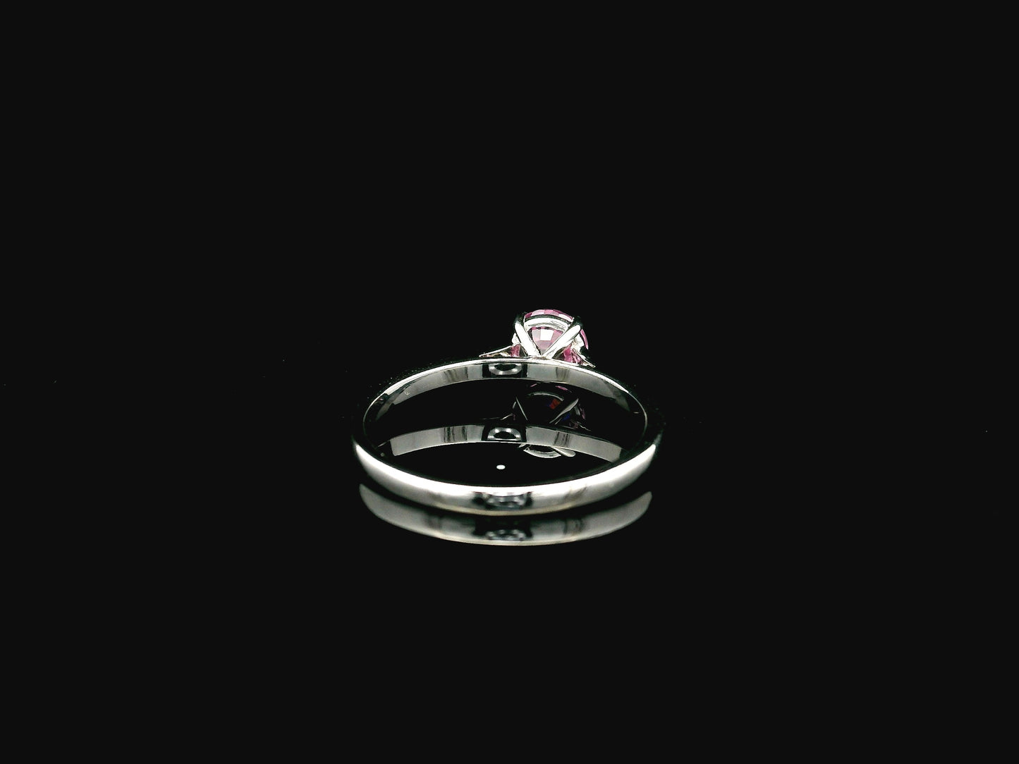 18K white gold pink sapphire solitaire ring featuring a 0.91 carat round pink sapphire in a classic four-prong setting