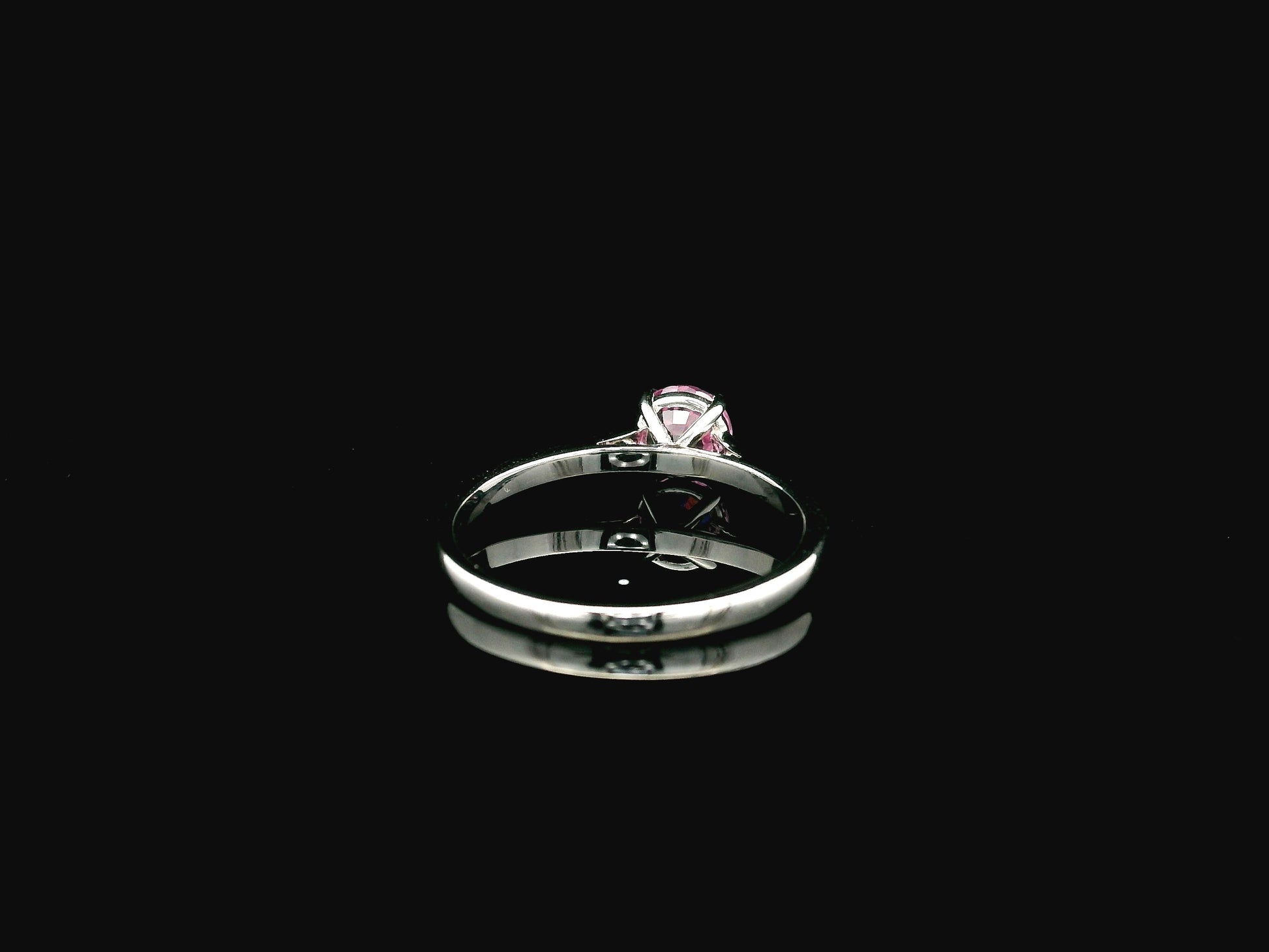 18K white gold pink sapphire solitaire ring featuring a 0.91 carat round pink sapphire in a classic four-prong setting