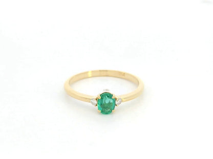Dainty oval emerald and diamond ring in 18K yellow gold by Emirates Diamonds