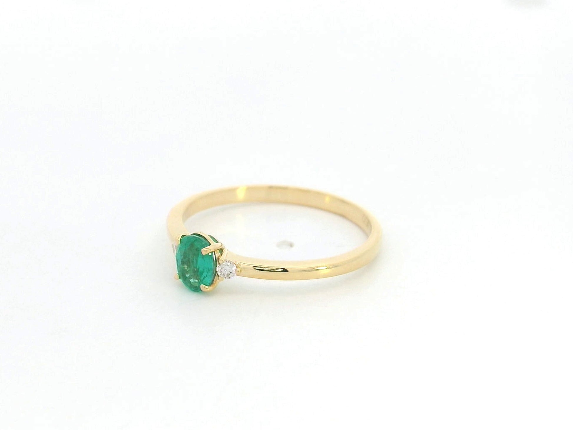 Dainty oval emerald and diamond ring in 18K yellow gold by Emirates Diamonds