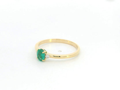 Dainty oval emerald and diamond ring in 18K yellow gold by Emirates Diamonds