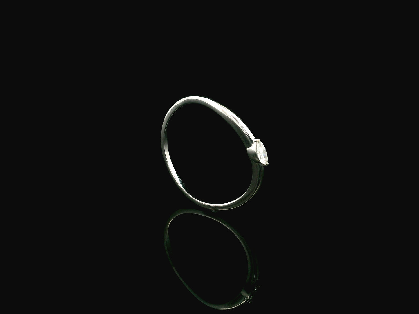 18K white gold solitaire ring featuring a 0.09 carat marquise cut natural diamond in a classic prong setting.