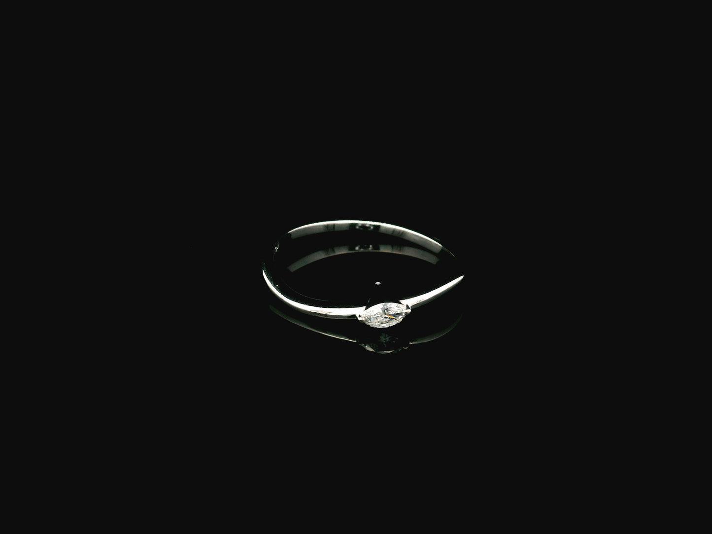 18K white gold solitaire ring featuring a 0.09 carat marquise cut natural diamond in a classic prong setting.