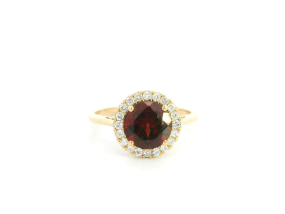 Garnet halo ring in 18K yellow gold featuring a 2.24 carat round garnet surrounded by natural diamonds