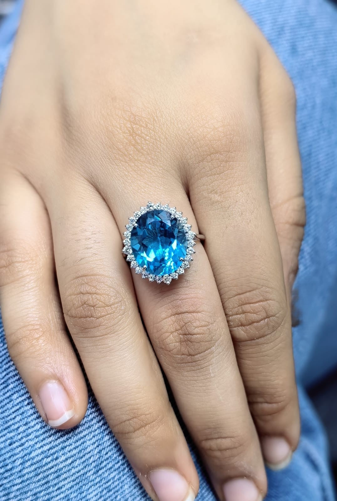 9.81 carat oval London Blue Topaz halo ring with natural diamonds in 18K white gold.