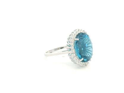 9.81 carat oval London Blue Topaz halo ring with natural diamonds in 18K white gold.