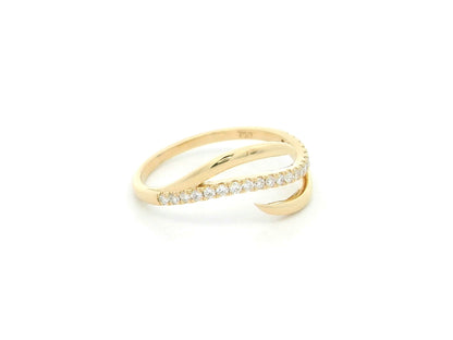 18K yellow gold diamond crossover ring featuring a flowing twist design set with 0.21 carat natural diamonds.