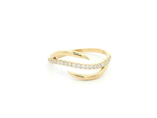18K yellow gold diamond crossover ring featuring a flowing twist design set with 0.21 carat natural diamonds.