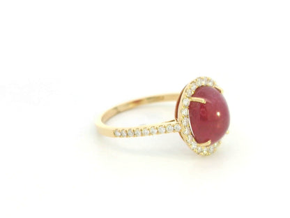 18K yellow gold ruby cabochon halo ring featuring a 4.17 carat natural oval ruby surrounded by 0.33 carat natural diamonds.