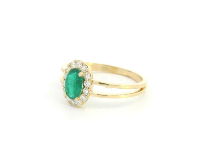 18K yellow gold emerald halo ring featuring a 0.56 carat oval natural emerald surrounded by a 0.28 carat natural diamond halo with an elegant split-band design.
